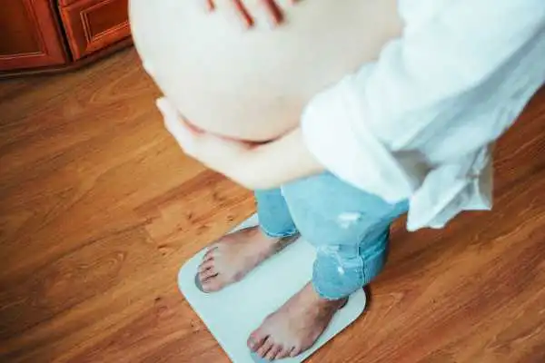 Image of woman weighing herself and experiencing weight gain through pregnancy Ryton on Dunsmore
